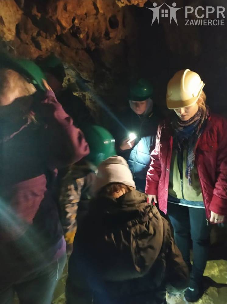 Zdjęcie: Grupa osób w kaskach na głowach znajduje się w jaskini